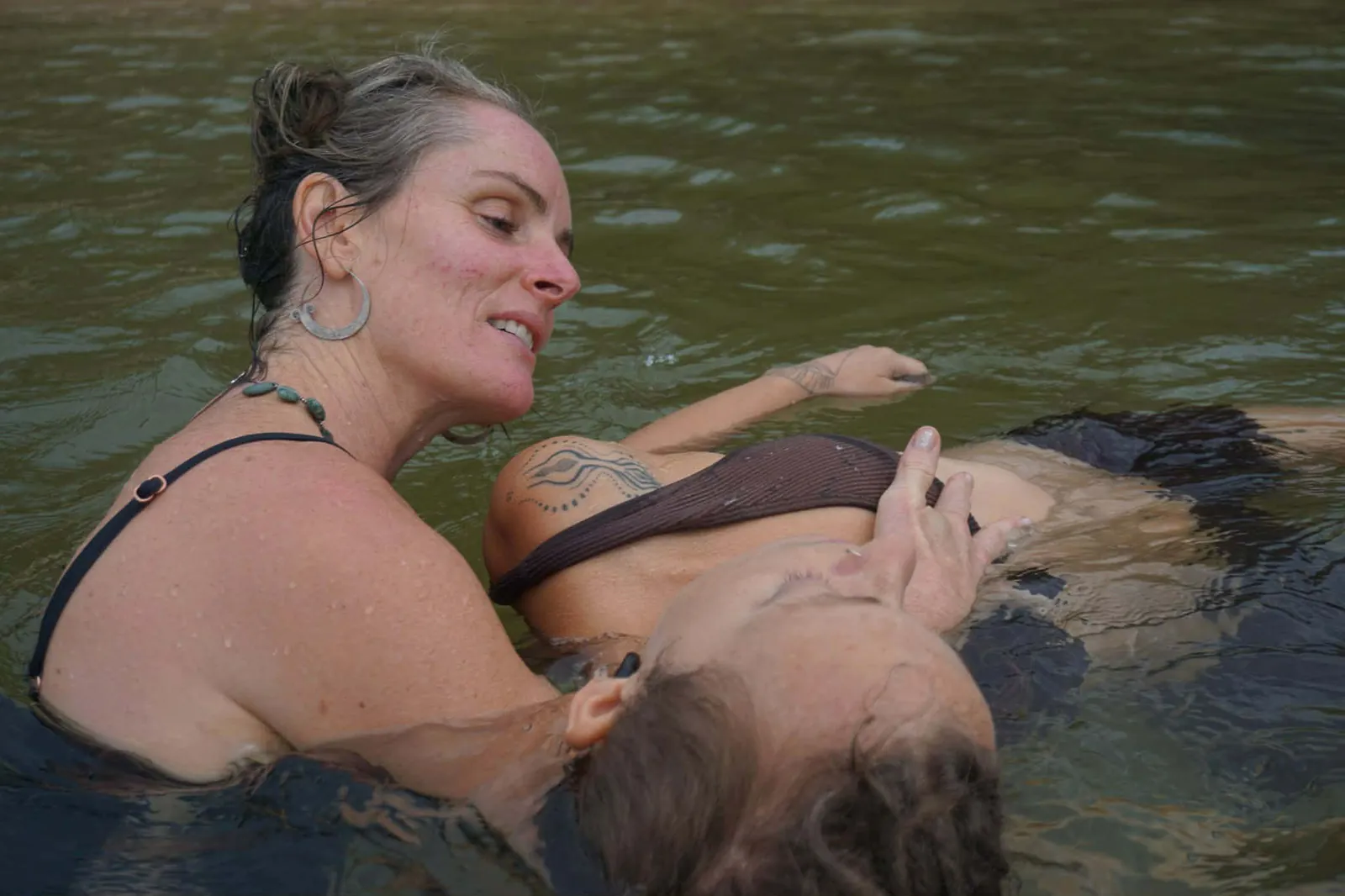 Two women laughing during an aquatic bodywork session